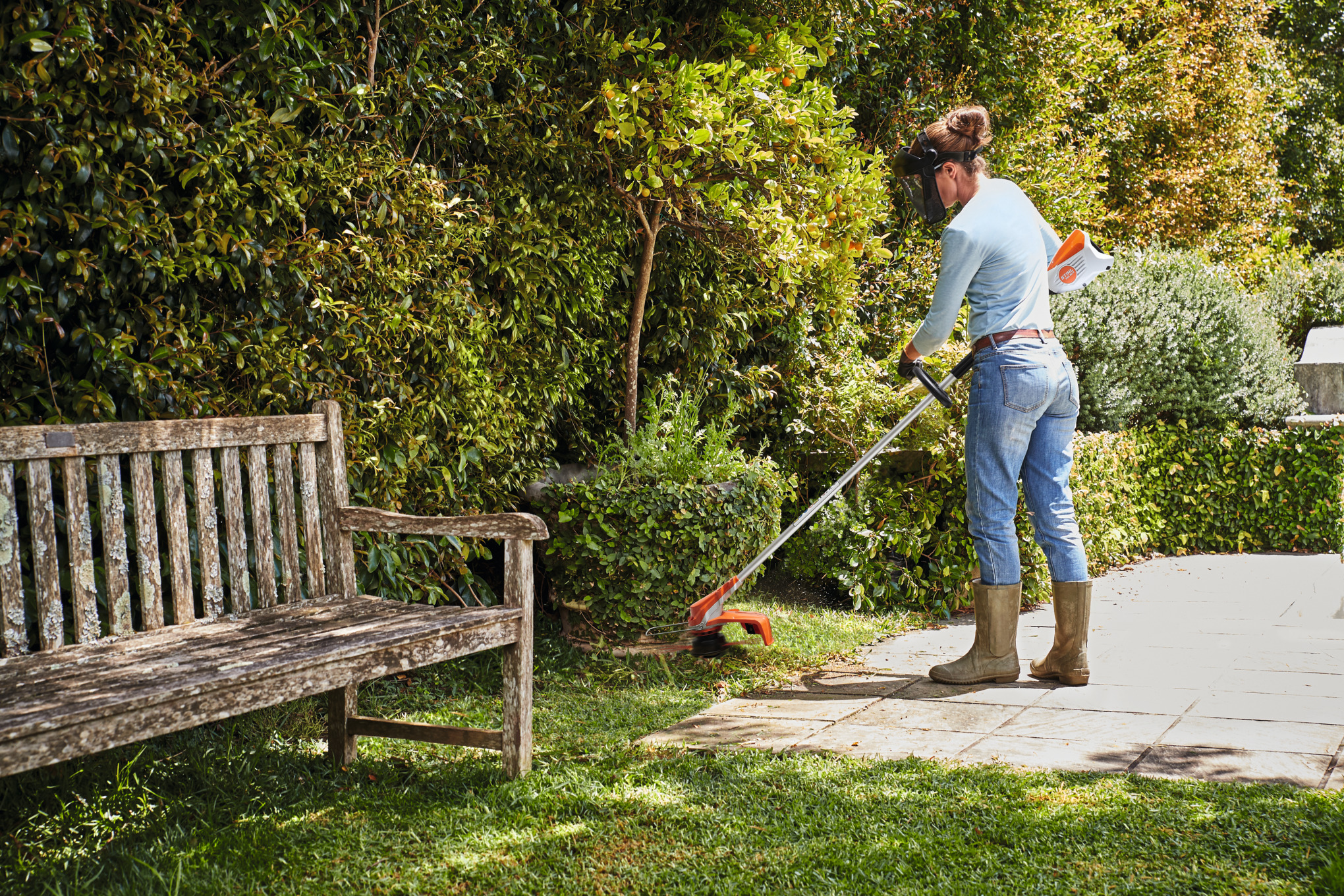 An individual using a FSA 60 to trim a there lawn.