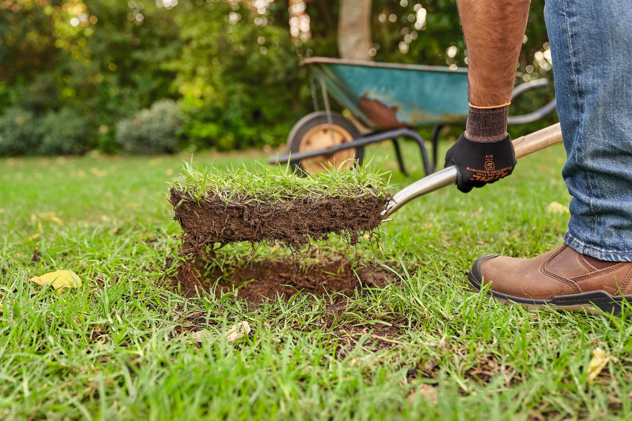 Close-up of someone removing the turf with a spade