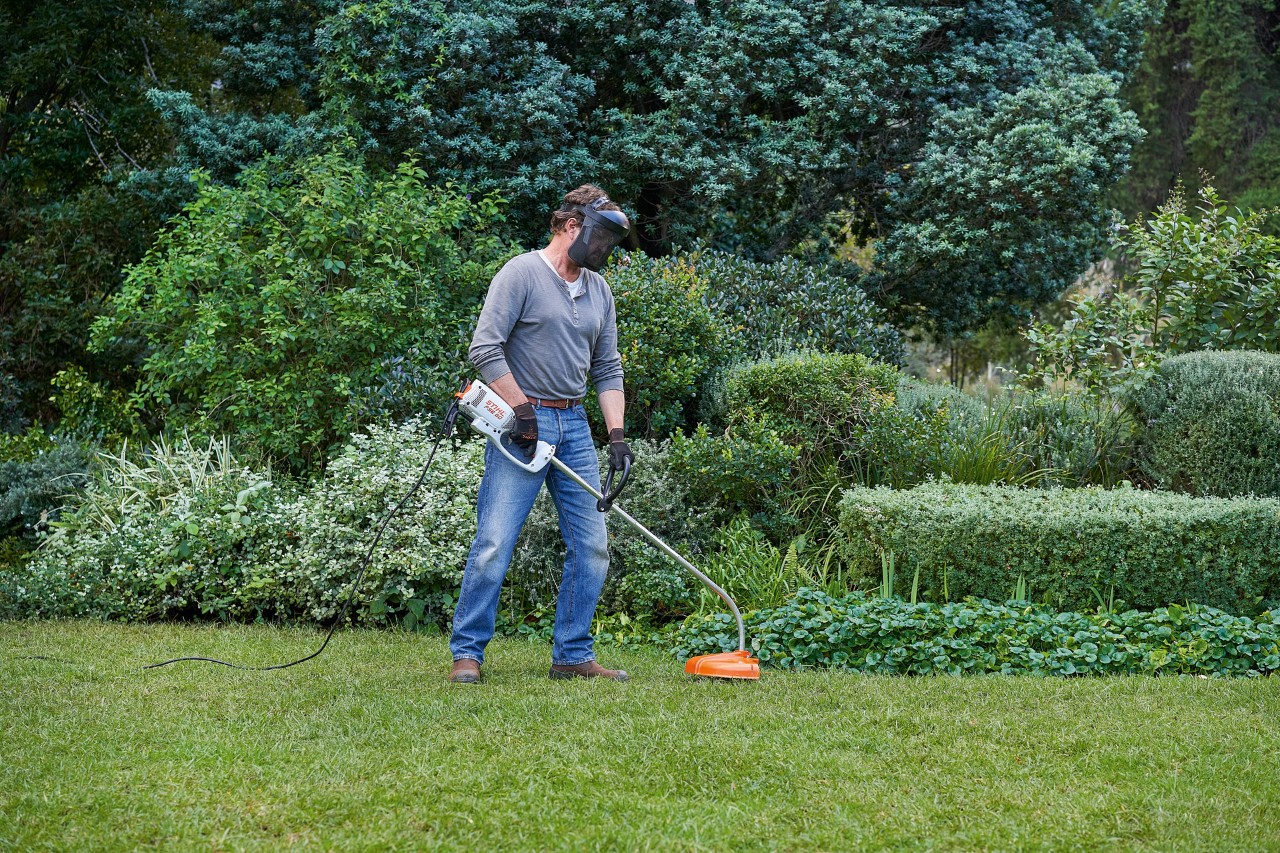 Un homme avec une débrousailleuse électrique STIHL&nbsp;FSE&nbsp;60 adoptant une position sûre