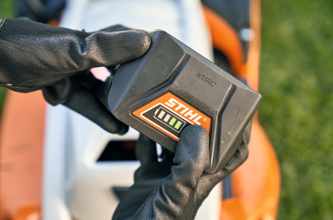 Batterie lithium-ion STIHL, en arrière-plan une tondeuse à batterie RMA 339 C de STIHL