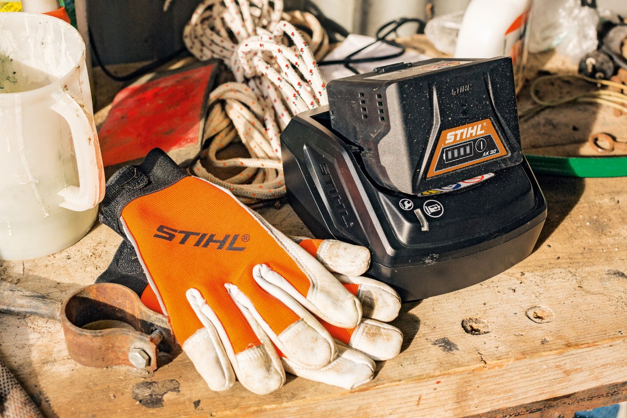 Batterie et gants posés sur un plan de travail