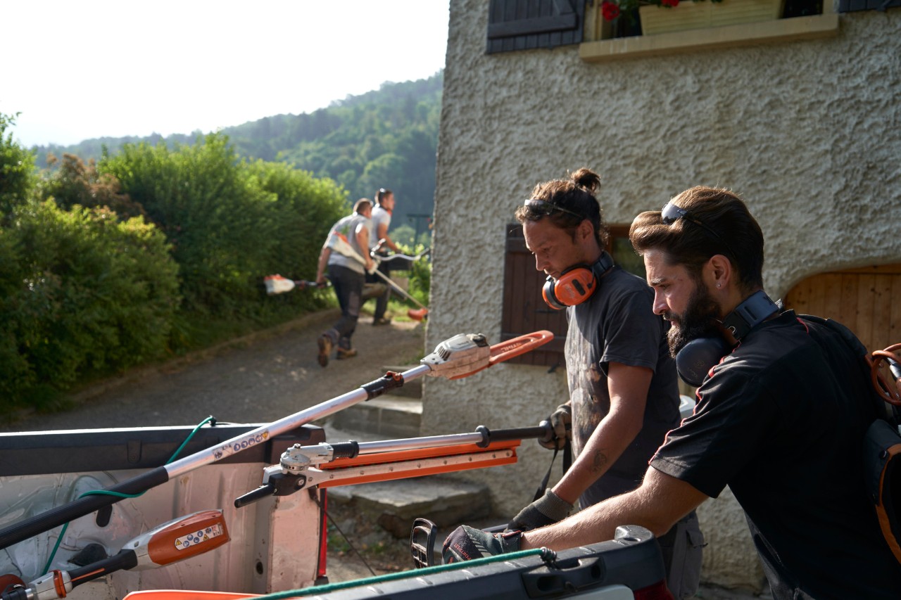 Ein Mitarbeiter der Farwick GmbH in Rückenansicht befindet sich vor einem bottTainer powered by STIHL